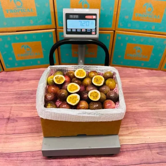 Fresh Maracuya passionfruits in a box, showcasing their vibrant yellow skins and juicy pulp