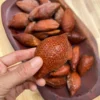 Fresh snake fruit in a box, showcasing its unique scaly skin and juicy white flesh.