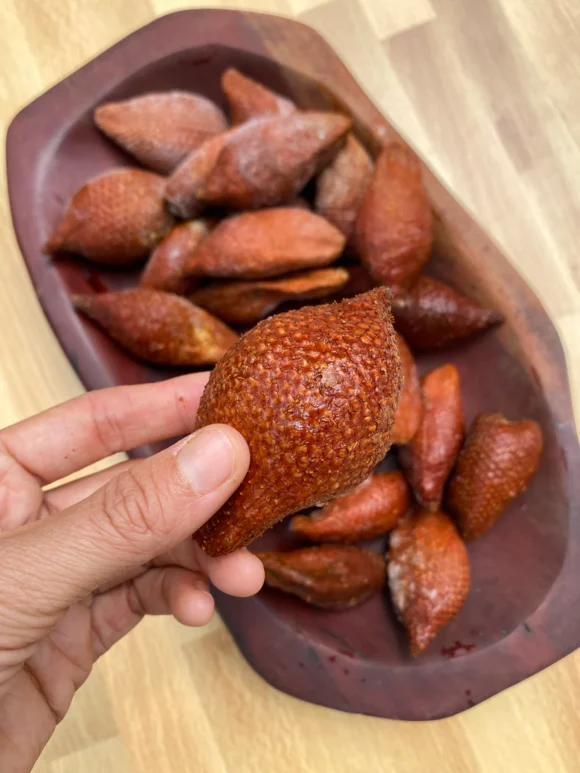 Fresh snake fruit in a box, showcasing its unique scaly skin and juicy white flesh.