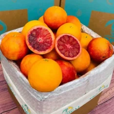 Blood orange fruit with deep red flesh and rosy blush skin in a fruit box